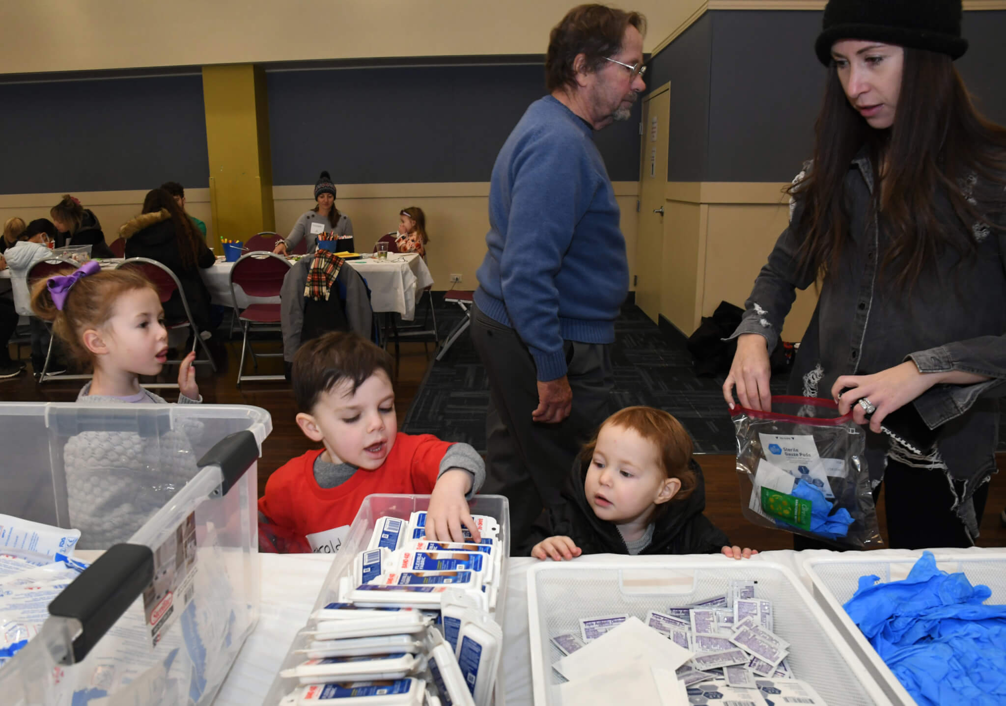 Children help assemble kits at Christmas Mitzvah family site