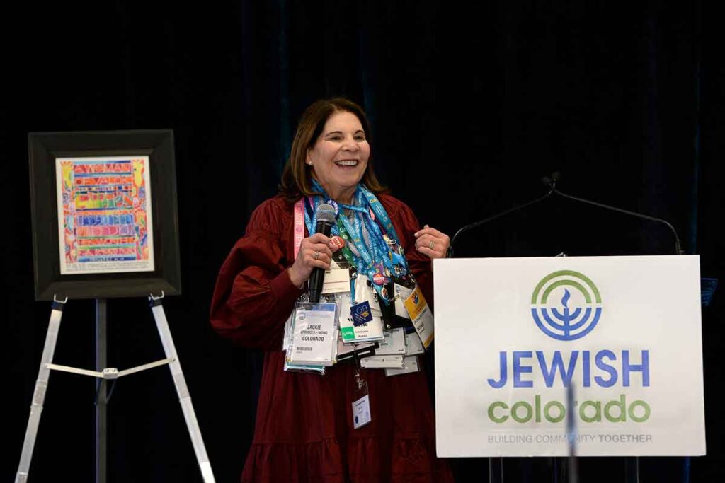 Jackie Sprinces Wong shows her many conference lanyards at the 2022 Cultivating Hope Luncheon presented by JEWISHcolorado Women's Philanthropy