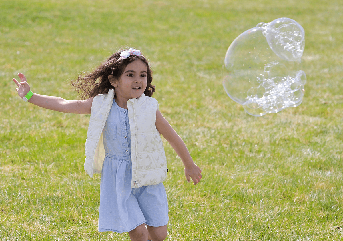 Girl playing with bubbles at Celebrate Israel @ 75